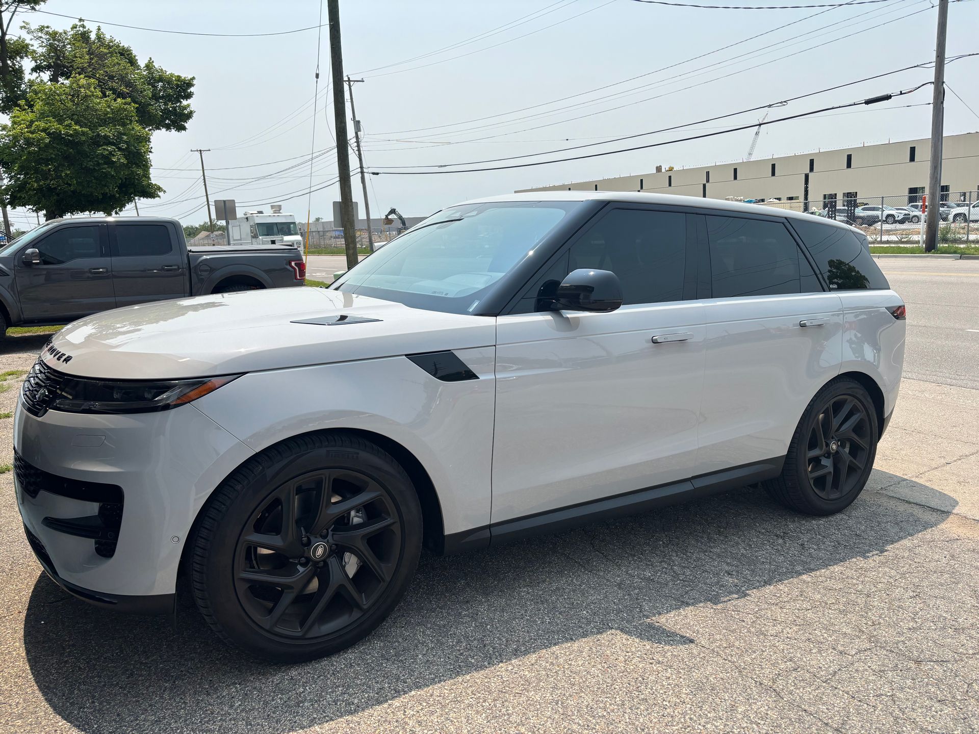 A white range rover sport is parked in a parking lot.