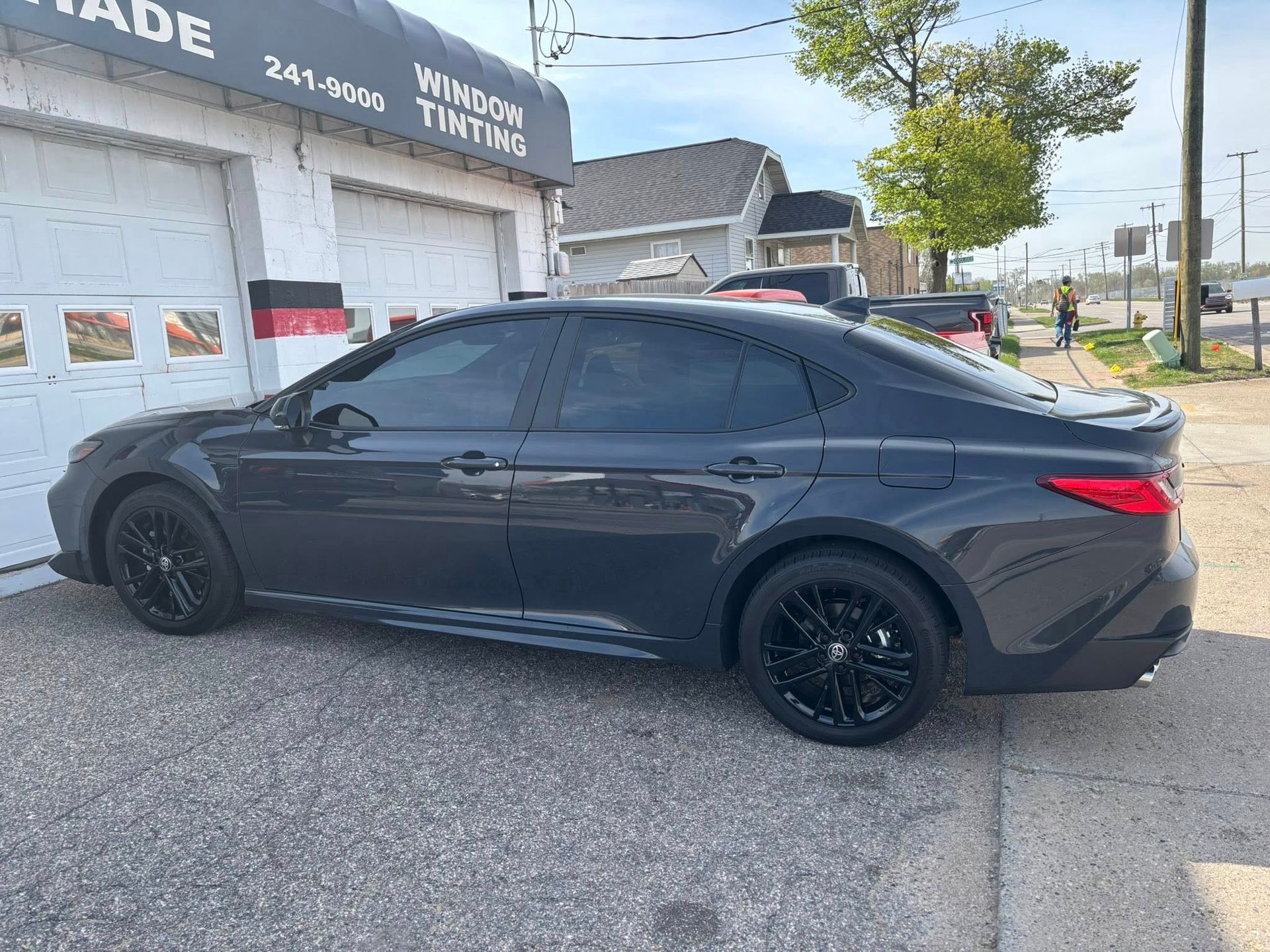 A black car is parked in front of a garage door.