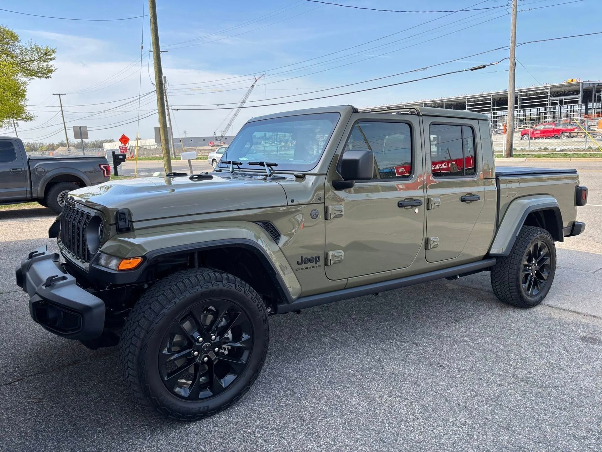 A jeep gladiator pickup truck is parked on the side of the road.