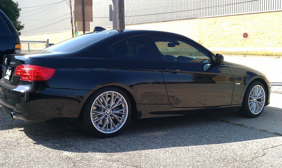 A black car is parked on the side of the road