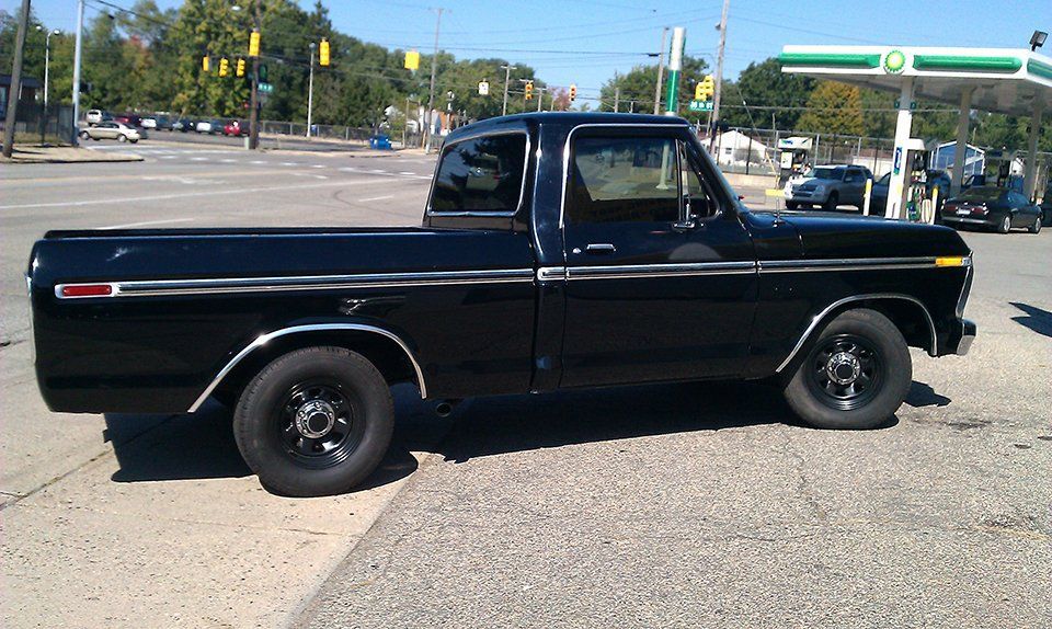A black truck is parked in front of a bp gas station