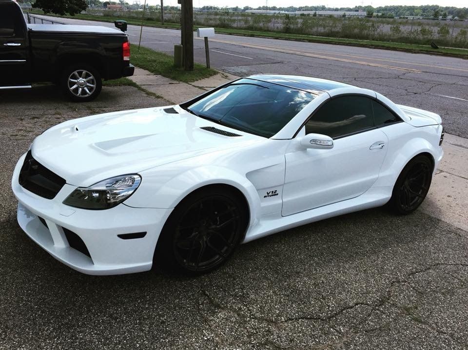 A white sports car is parked on the side of the road