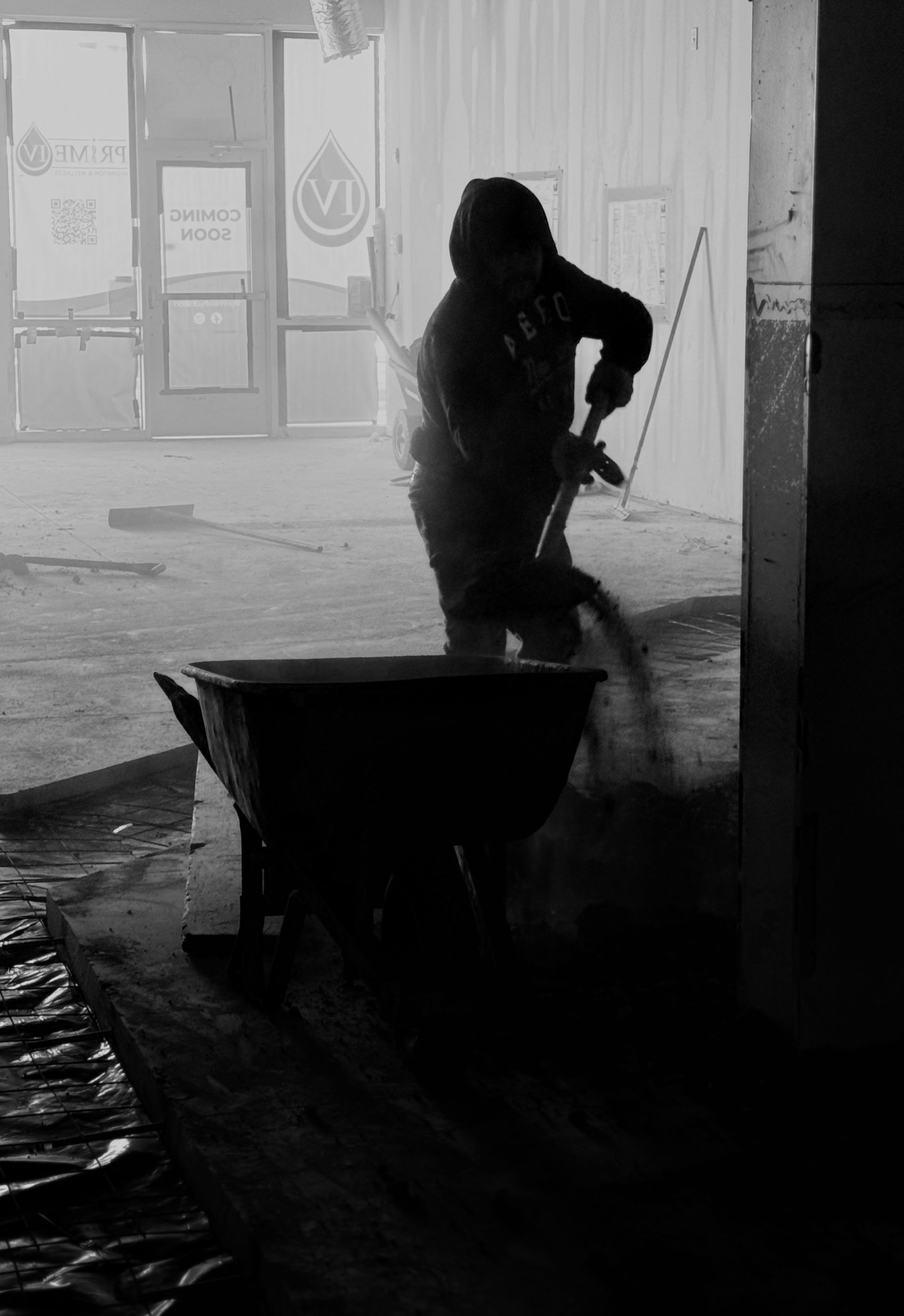 A black and white picture of a worker shoveling