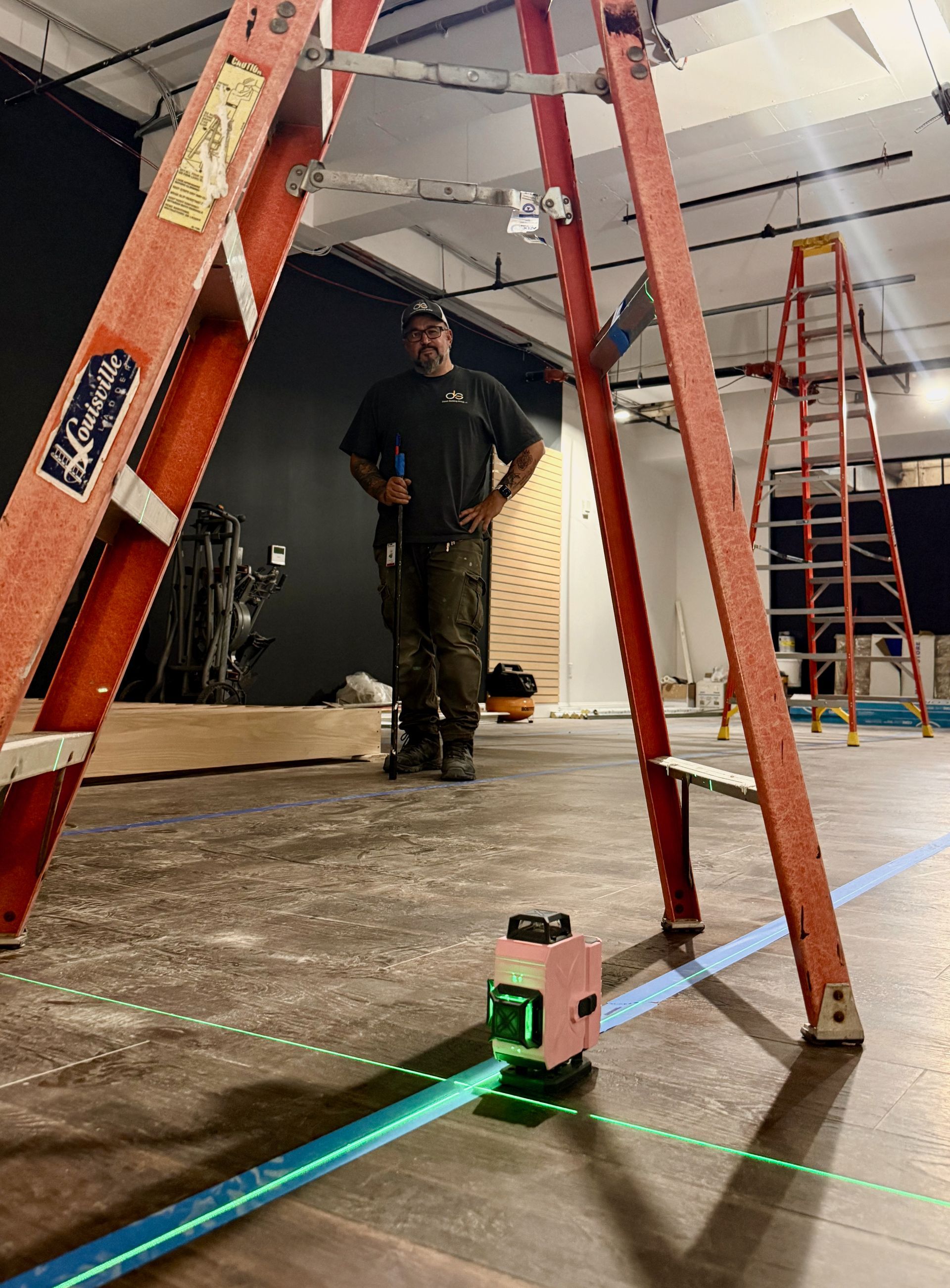 A picture of a ladder and a worker taking a measurment