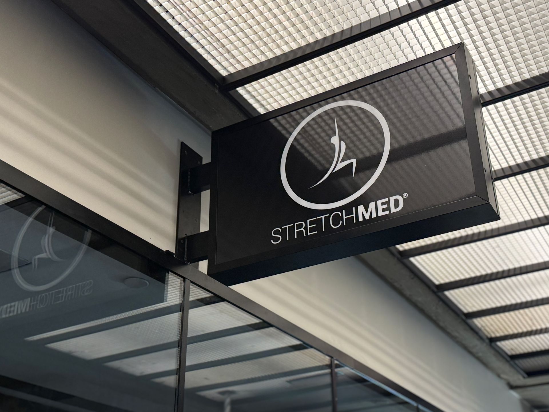 A black double-sided business sign for 