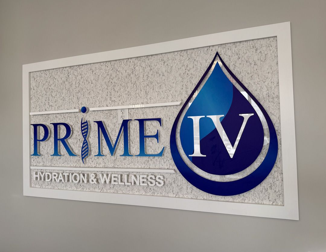 A rectangular sign for Prime IV Hydration & Wellness featuring a DNA helix in the letter I and a blue water drop logo.