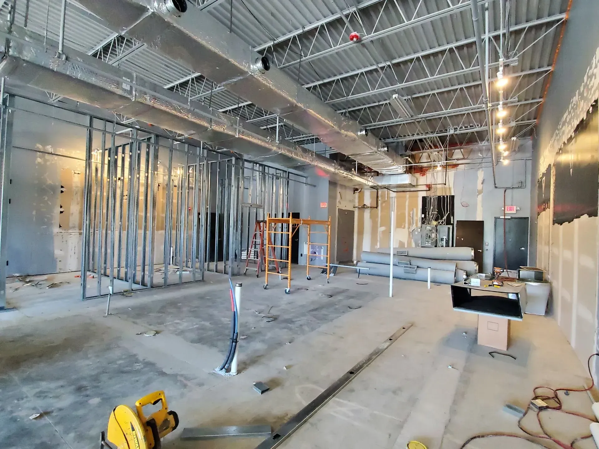 Interior of a commercial building under construction; metal framing, exposed ceiling, concrete floor.