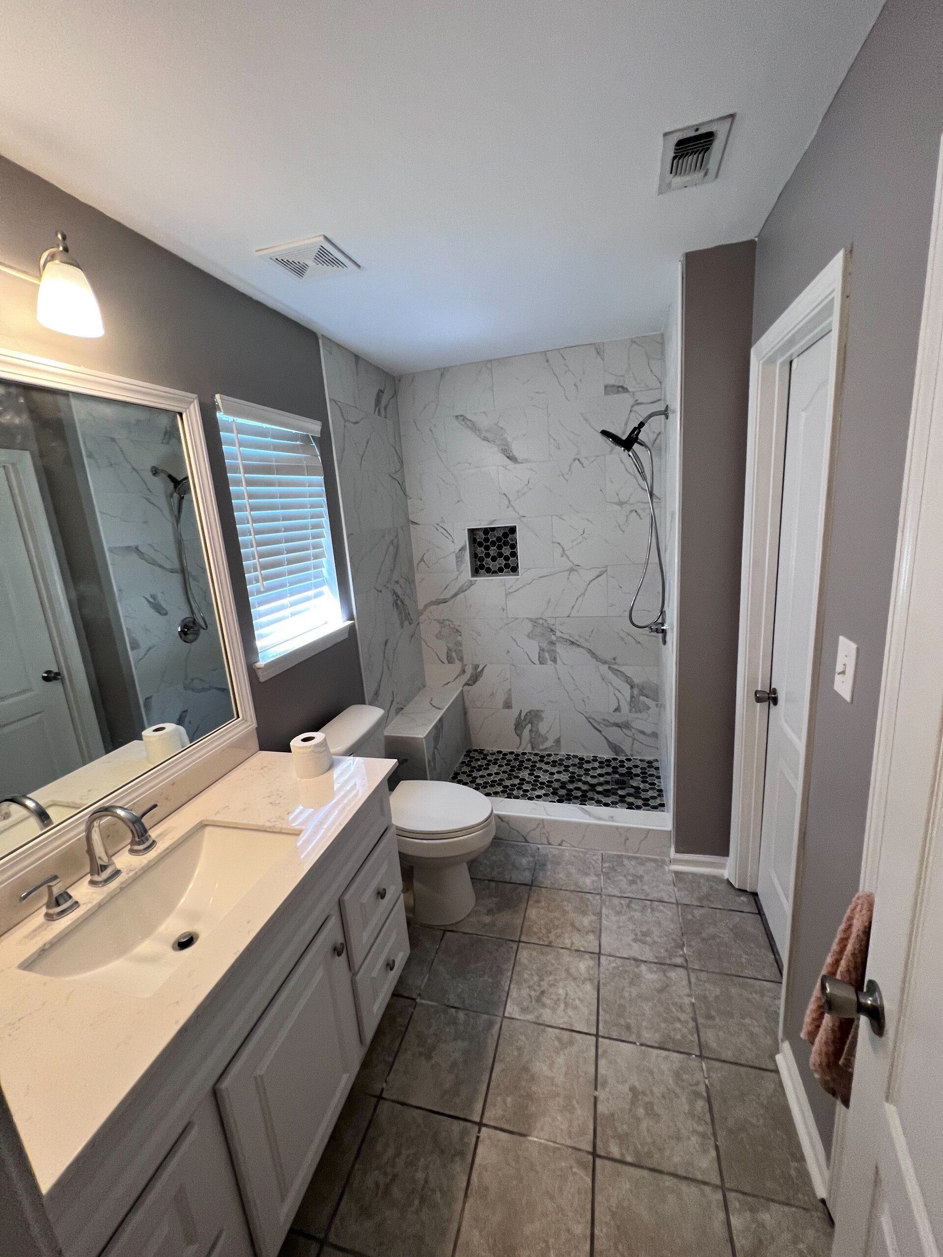 remodeled gray and white bathroom with marble