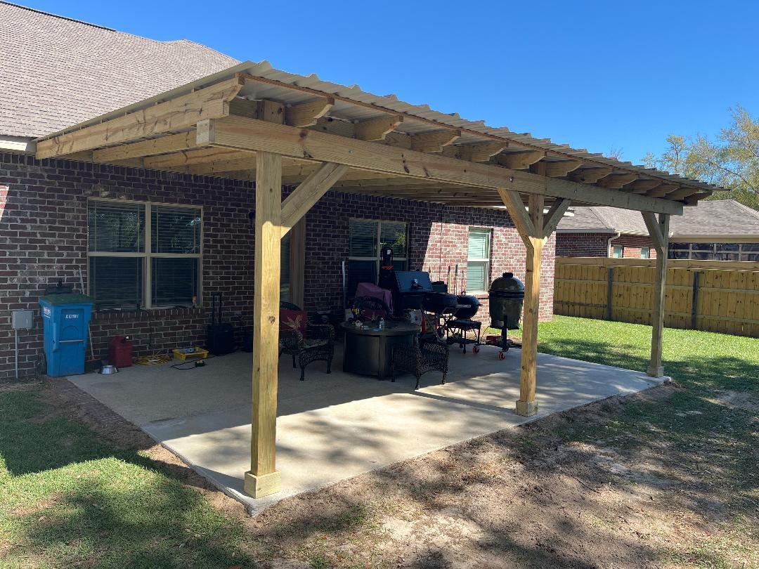 A wooden pergola is sitting in the backyard of a brick house.
