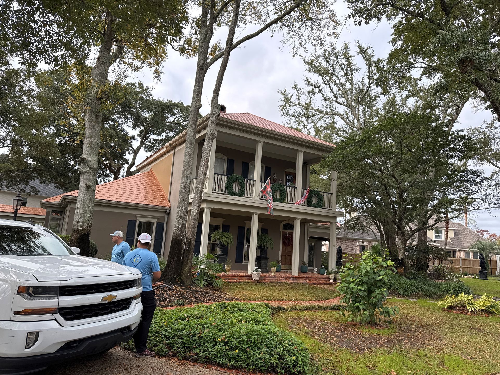A white truck is parked in front of a large house