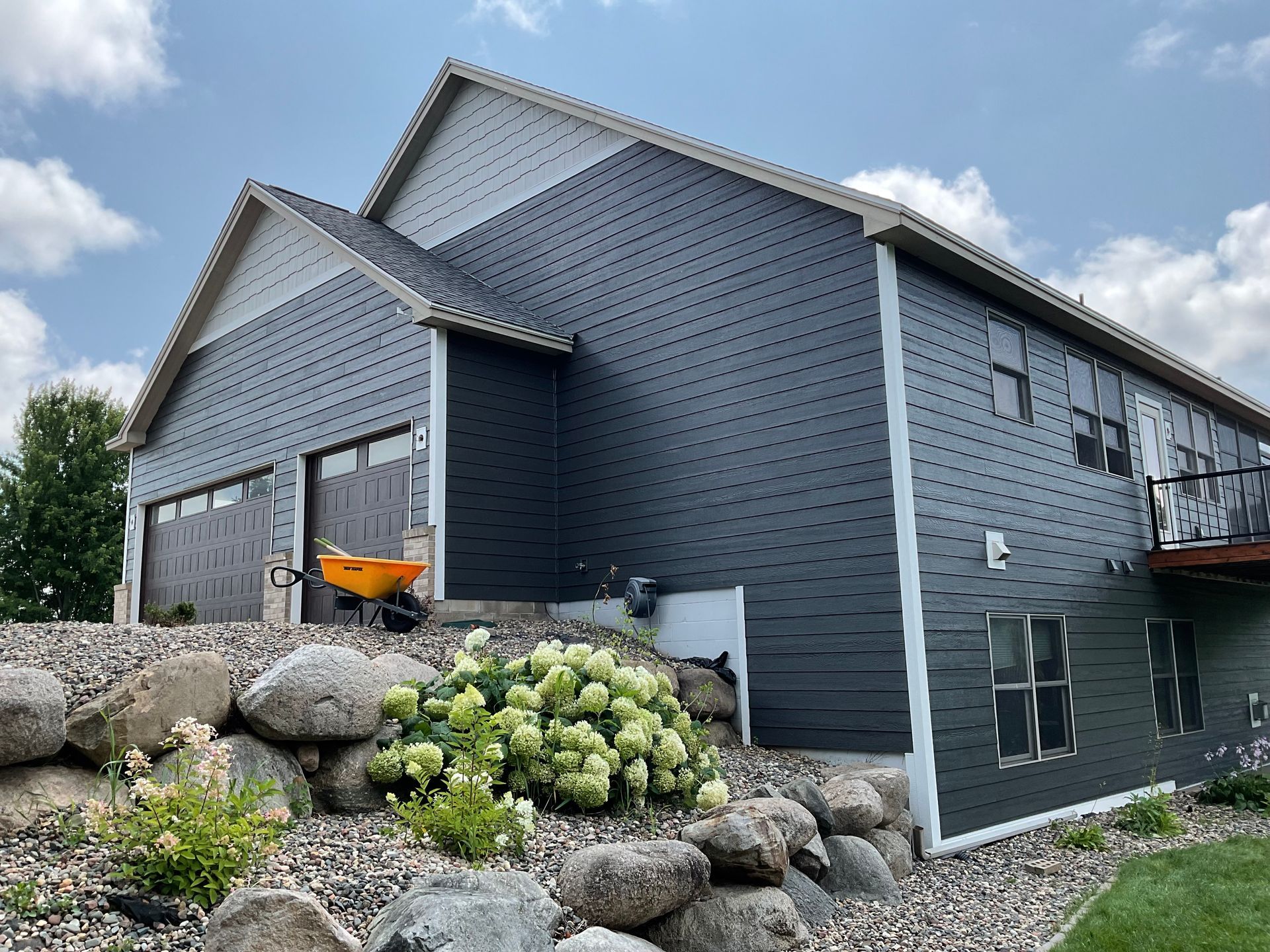 A large house with a wheelbarrow parked in front of it.