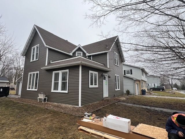 A man is working on the side of a house.