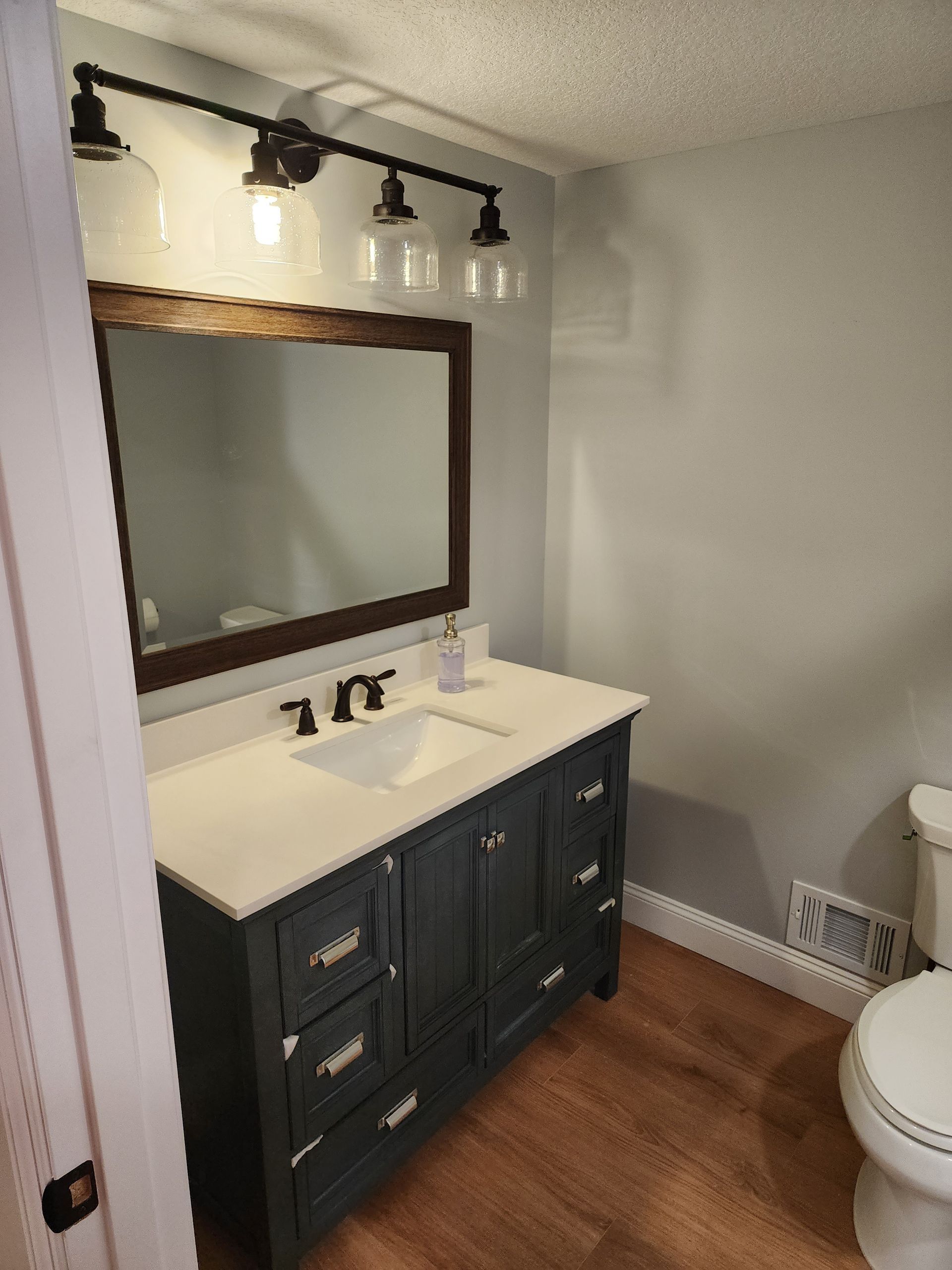 A bathroom with a sink , toilet and mirror