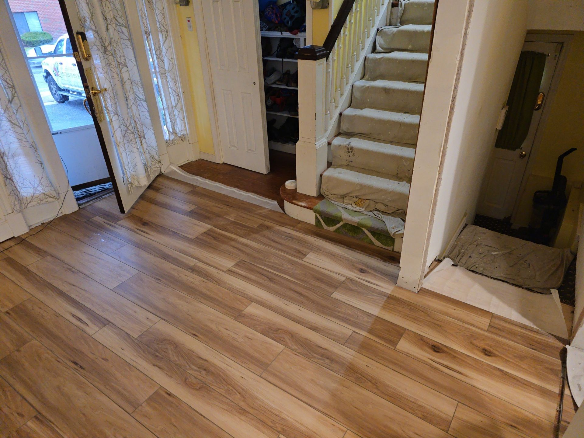 Wooden-floored entry with stairs, door to outside, and shoe storage.