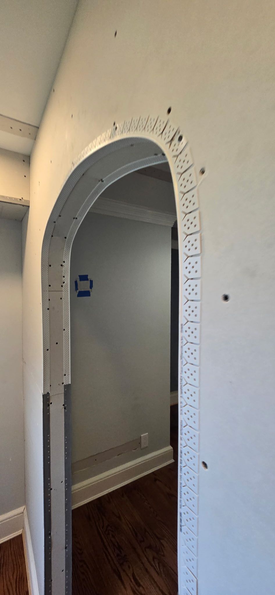 An arched doorway frame with metal edging. The interior of the doorway is visible.