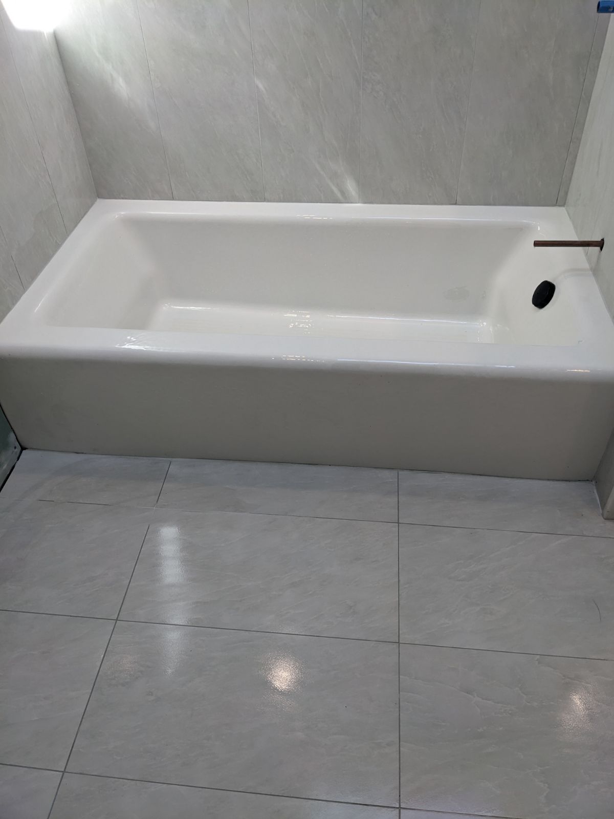 White bathtub in a tiled bathroom. Black faucet, white walls and floor tiles.