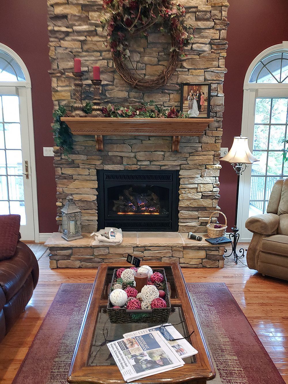 A living room with a stone fireplace and a coffee table.