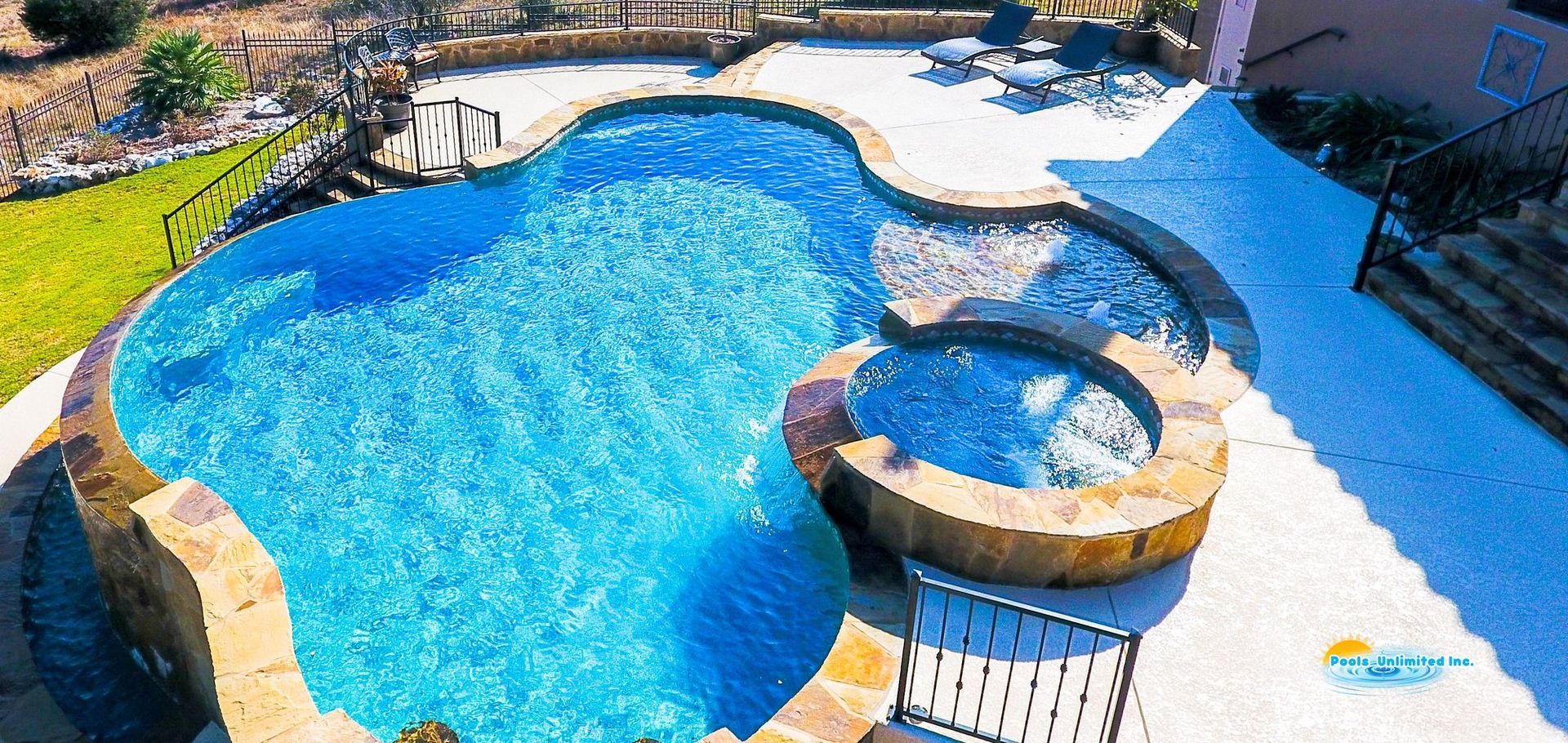 An aerial view of a large swimming pool in a backyard.