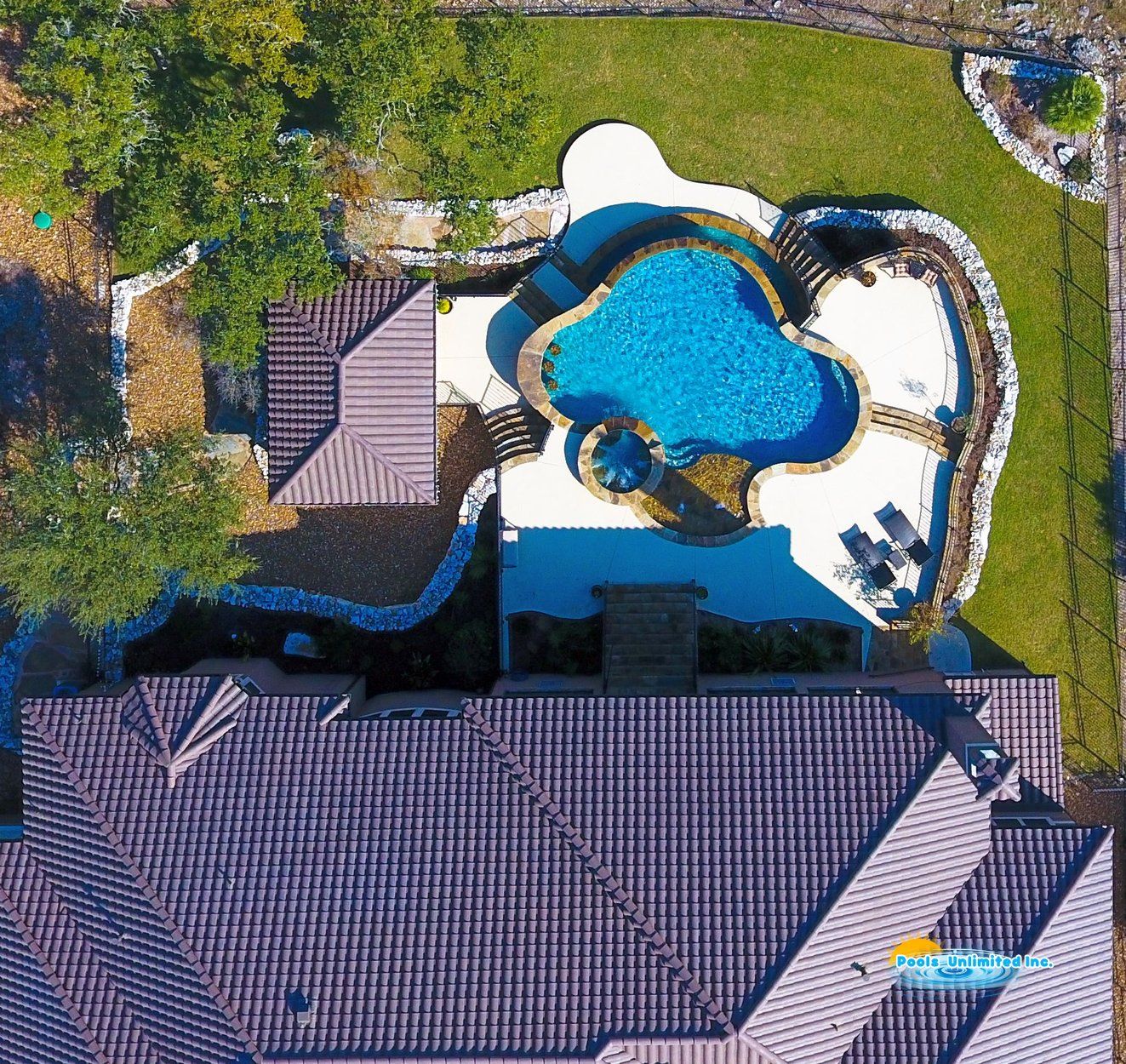 An aerial view of a house with a large swimming pool