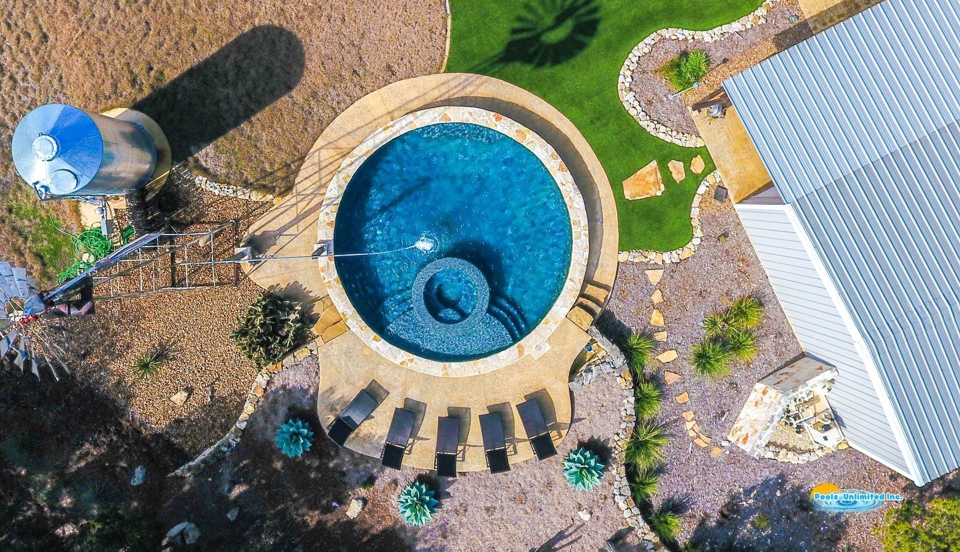 An aerial view of a large swimming pool in a backyard.
