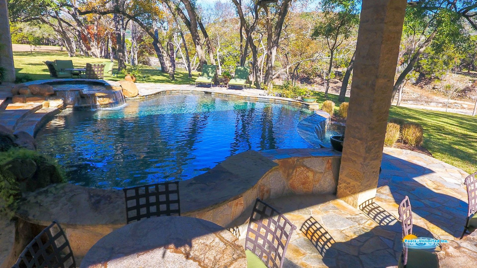 A large swimming pool with a house in the background