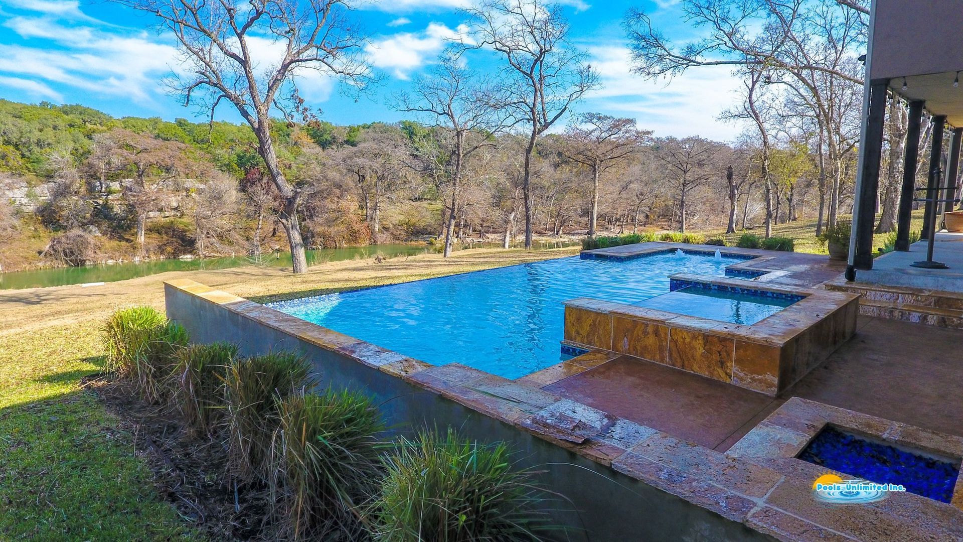 An aerial view of a large swimming pool in the backyard of a house.