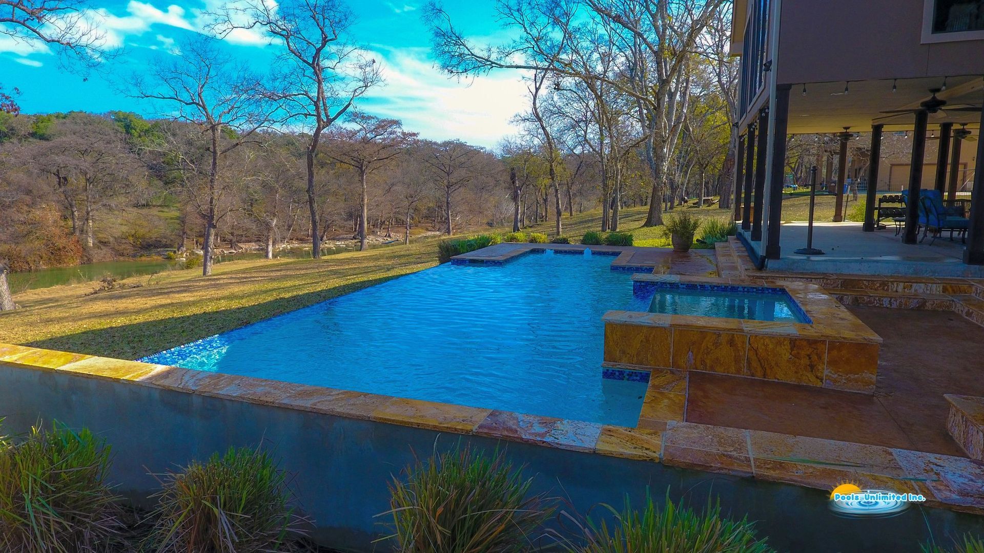 An aerial view of a large swimming pool with a gazebo in the background