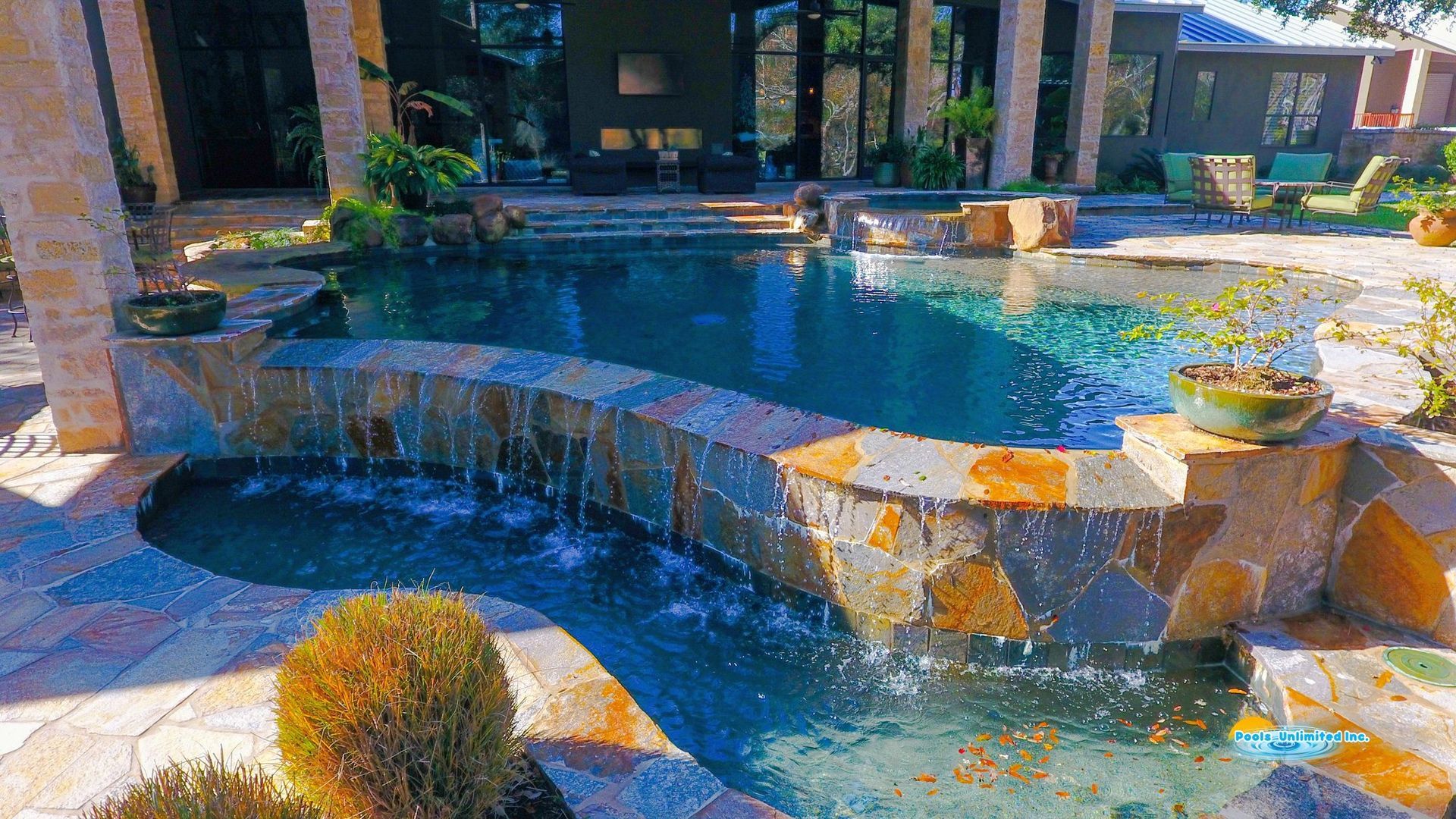 A large swimming pool surrounded by rocks and palm trees