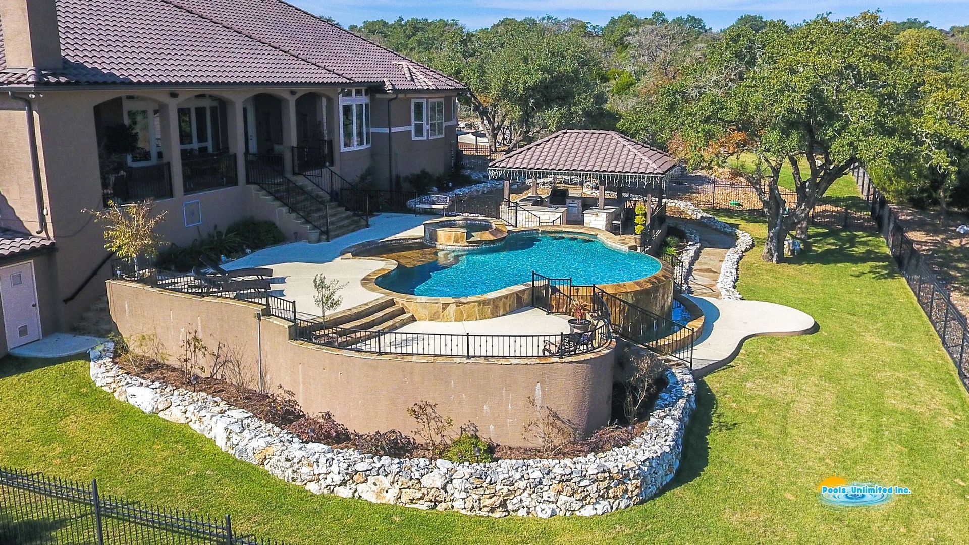 There is a large swimming pool in the backyard of a house.