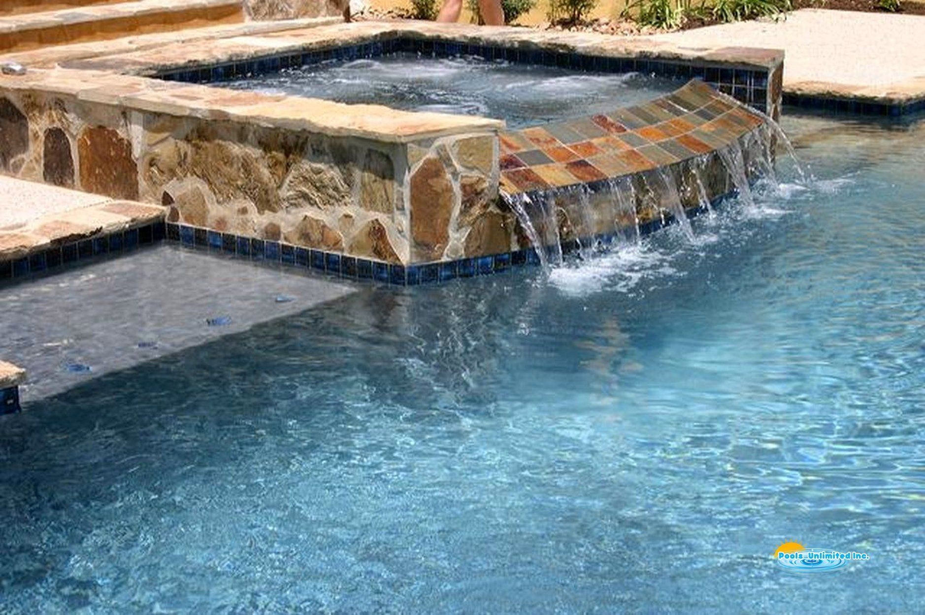 There is a waterfall in the middle of the pool.
