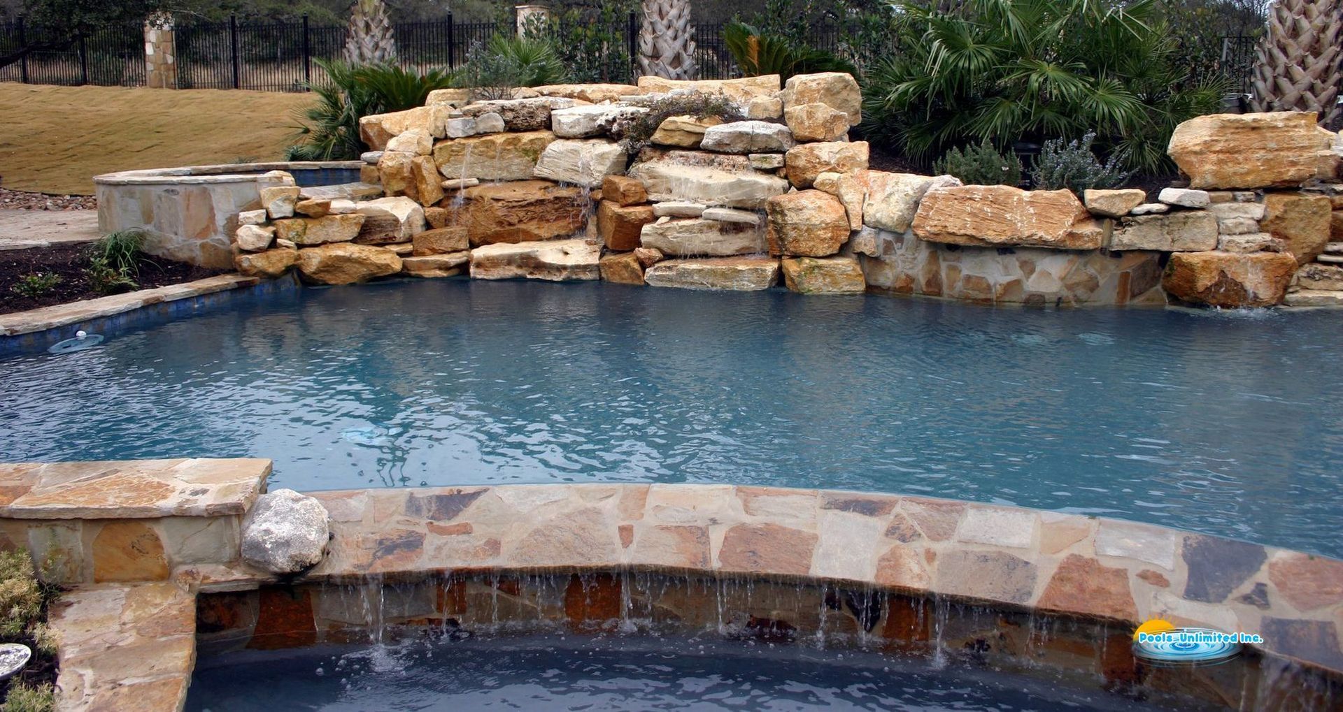 There is a waterfall in the middle of the pool.