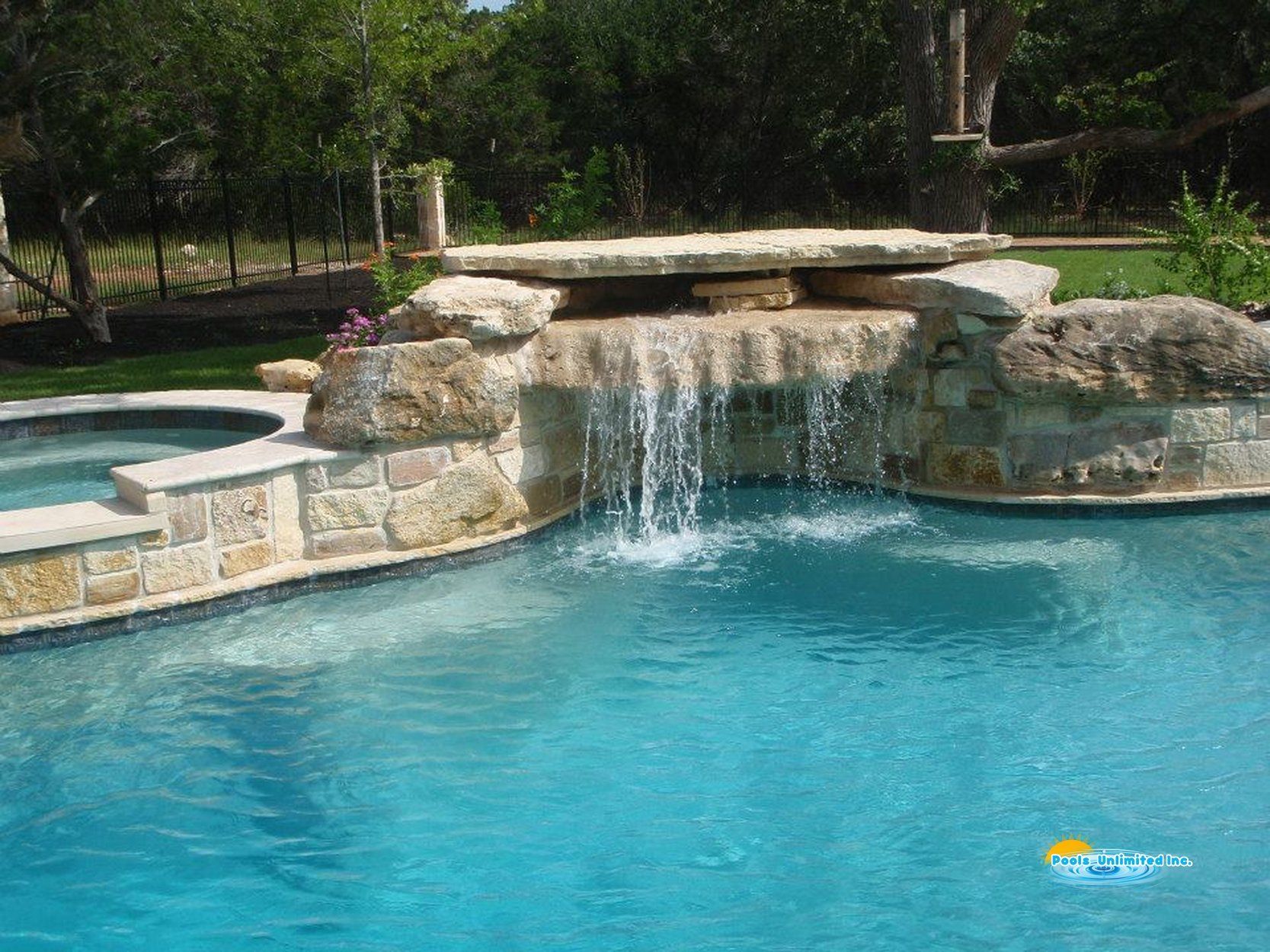 There is a waterfall in the middle of the pool.