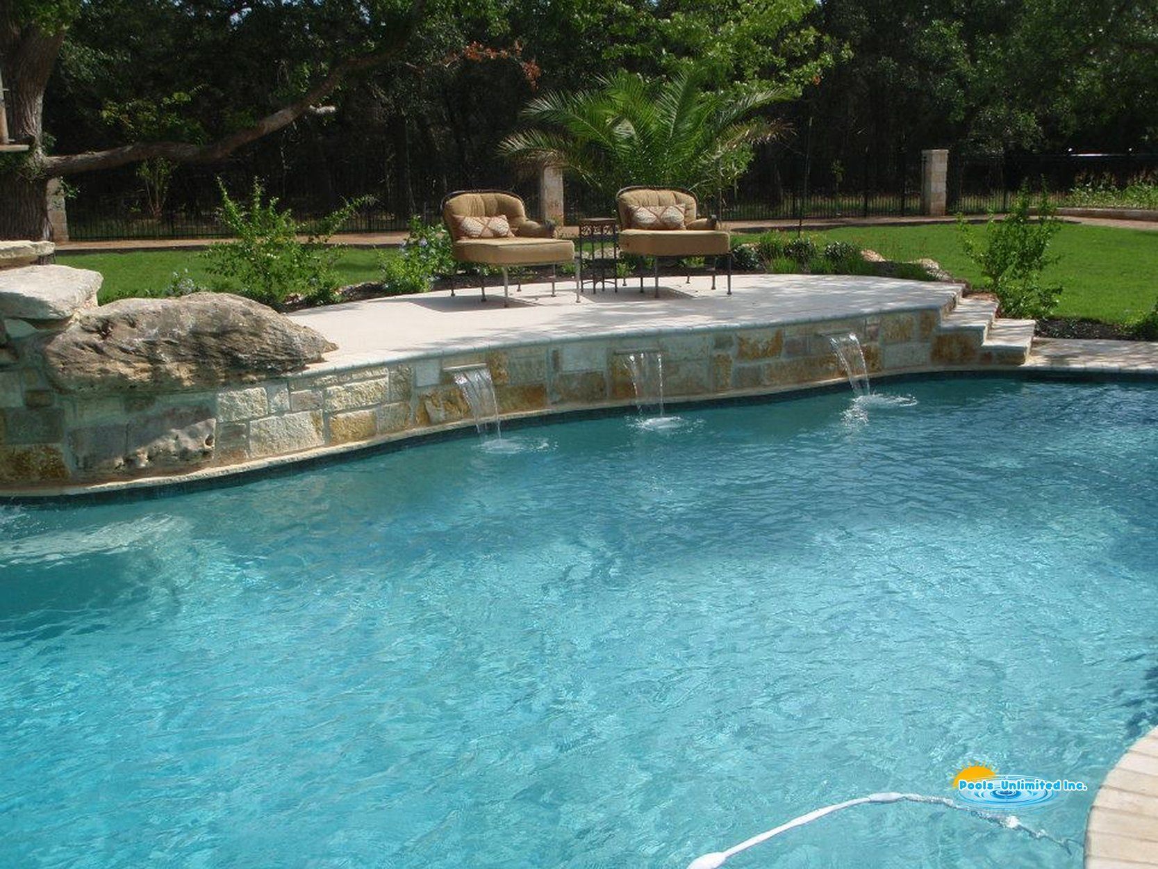 A large swimming pool with a waterfall in the middle
