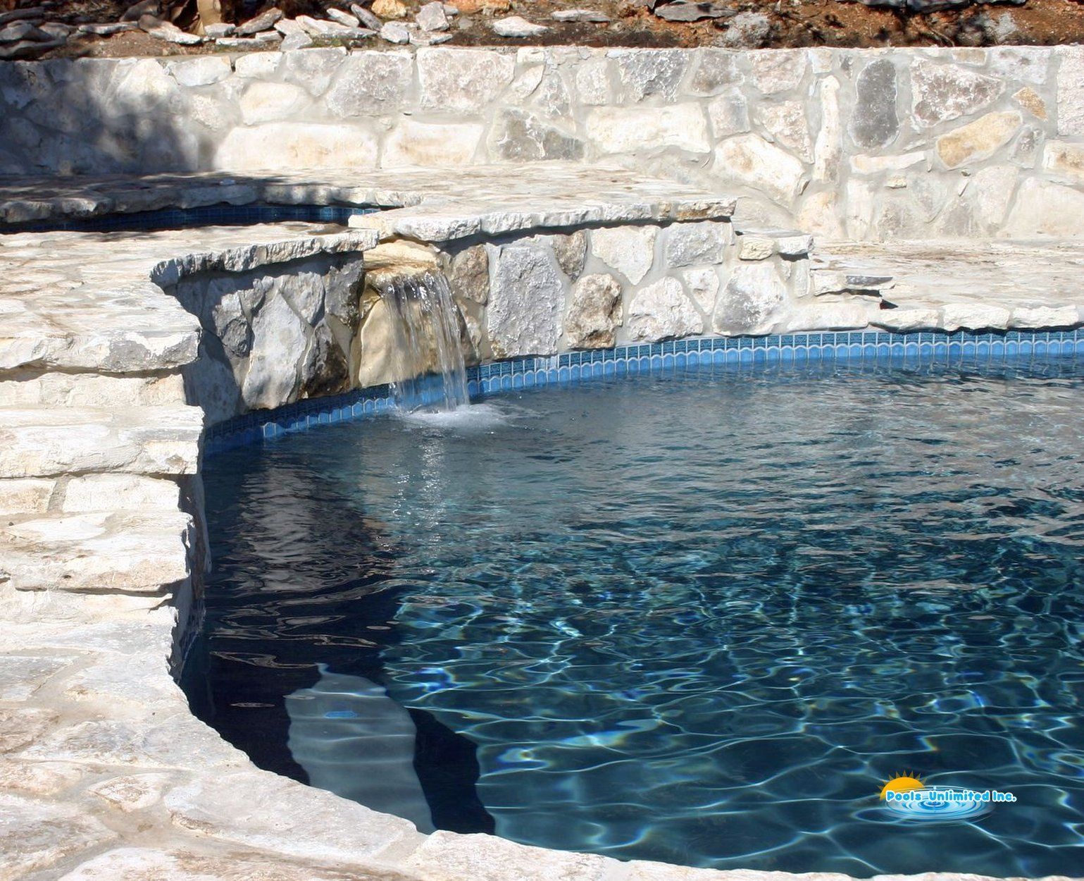 A swimming pool with a waterfall in the middle