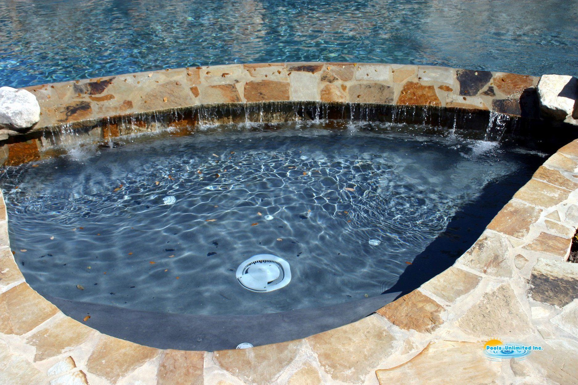 A pool with a waterfall in the middle of it
