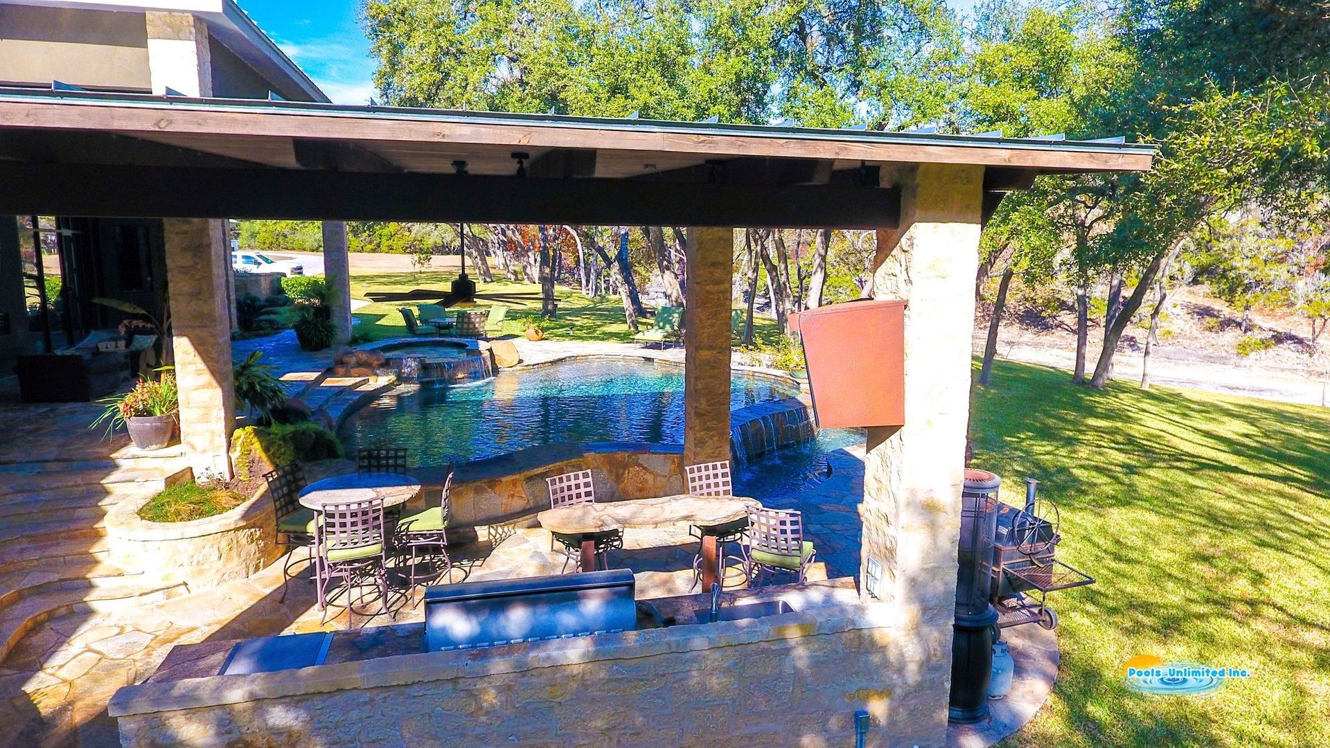 An aerial view of a patio area with tables and chairs under a pergola.