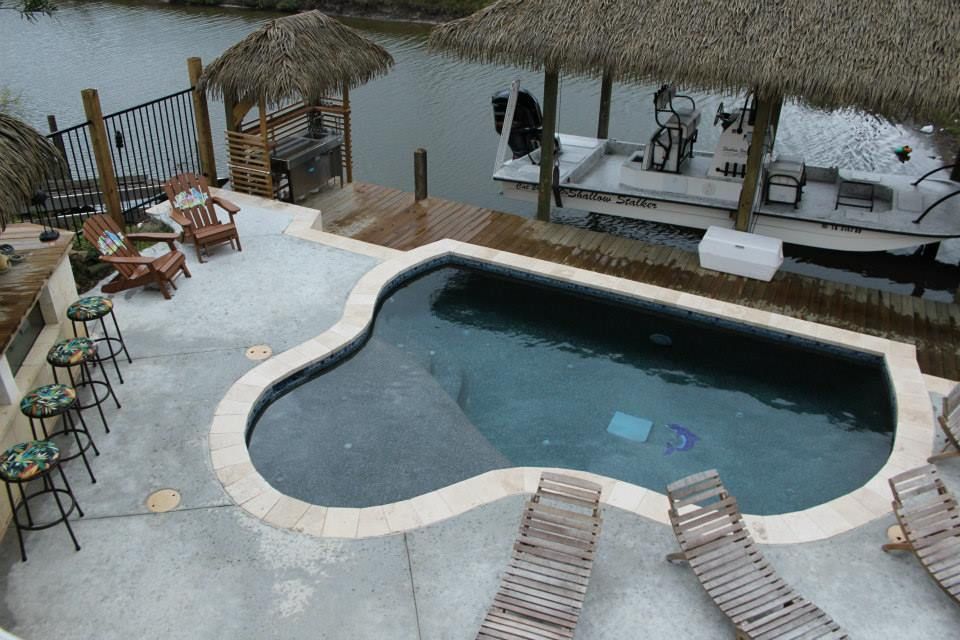 A large swimming pool with a boat in the background