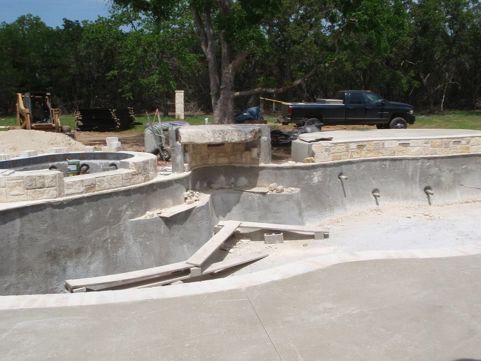 A truck is parked in front of a swimming pool under construction