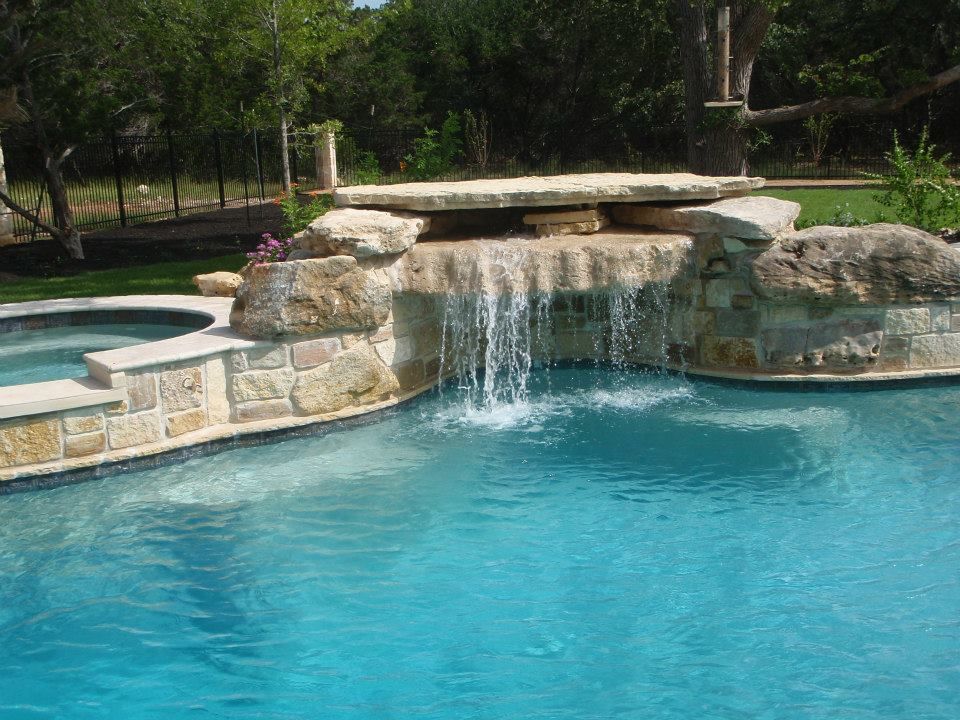 A swimming pool with a waterfall in the middle of it