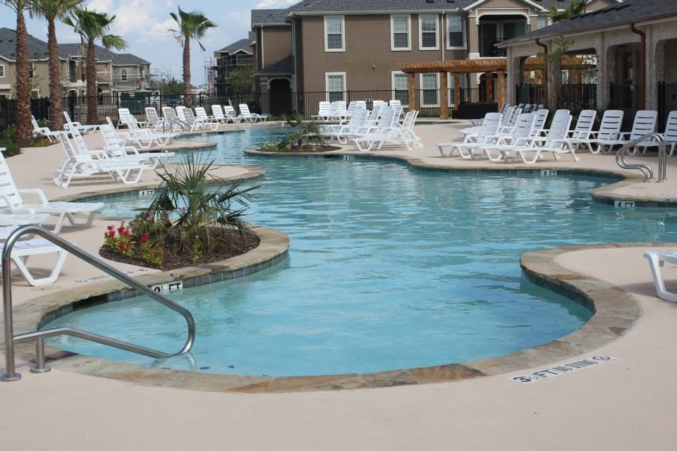 A large swimming pool with lots of chairs around it