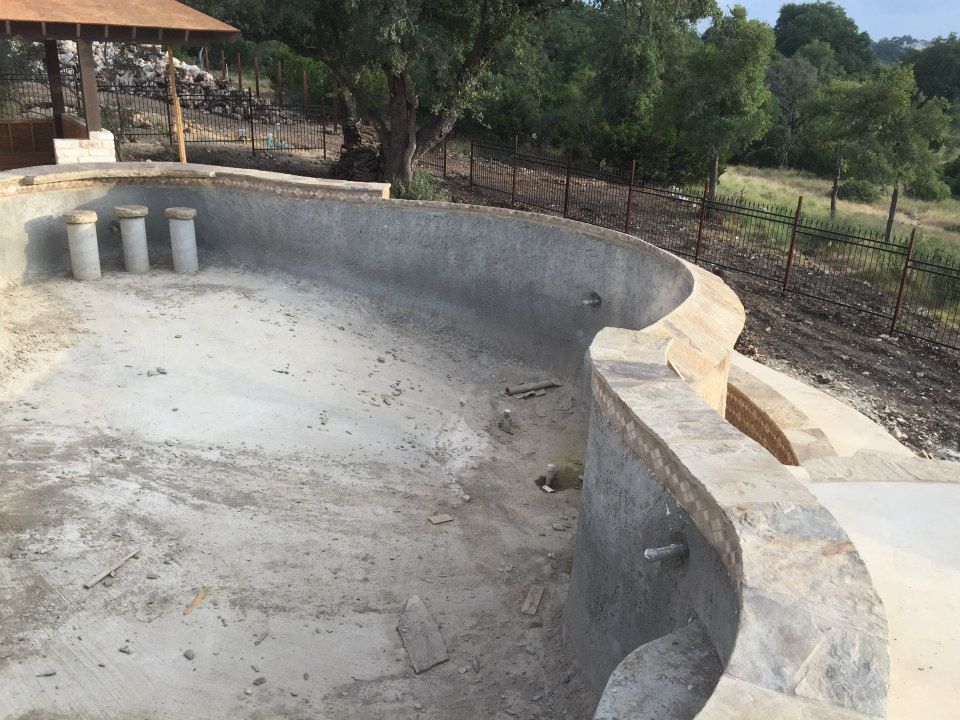 An empty swimming pool with a fence in the background