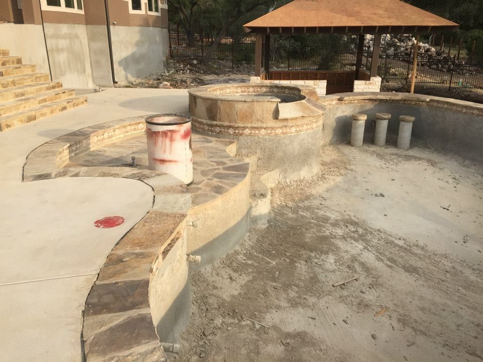 A swimming pool is being built with a gazebo in the background