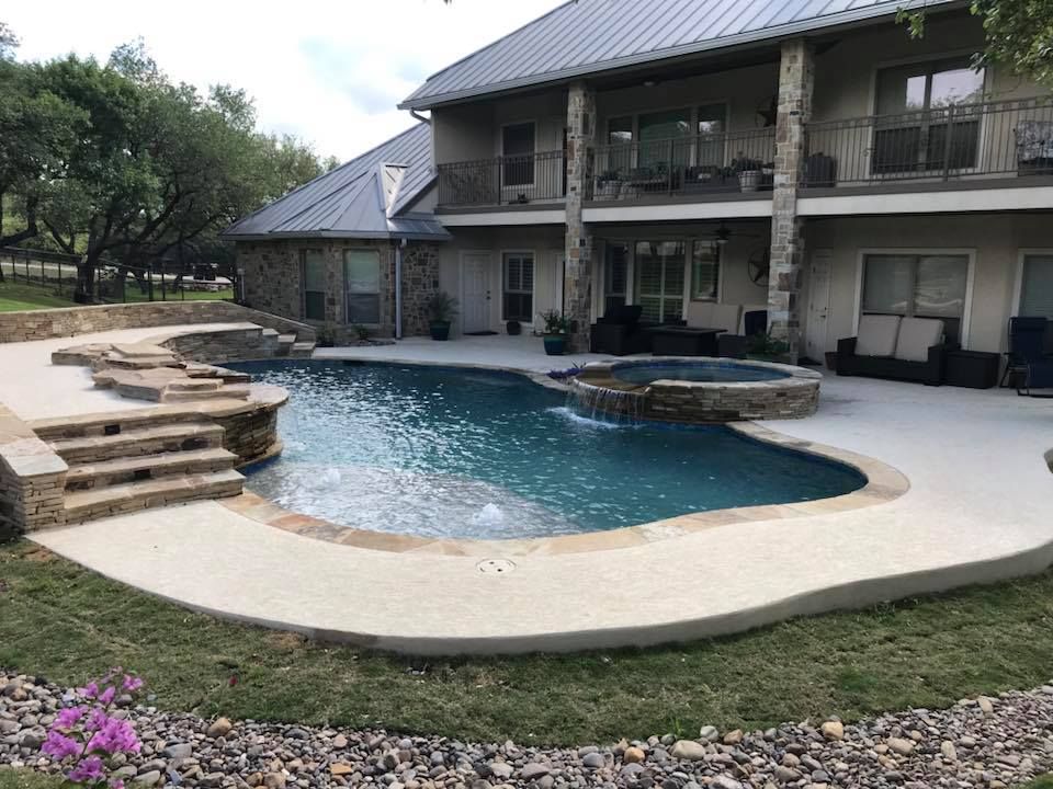 A large house with a large swimming pool in front of it.