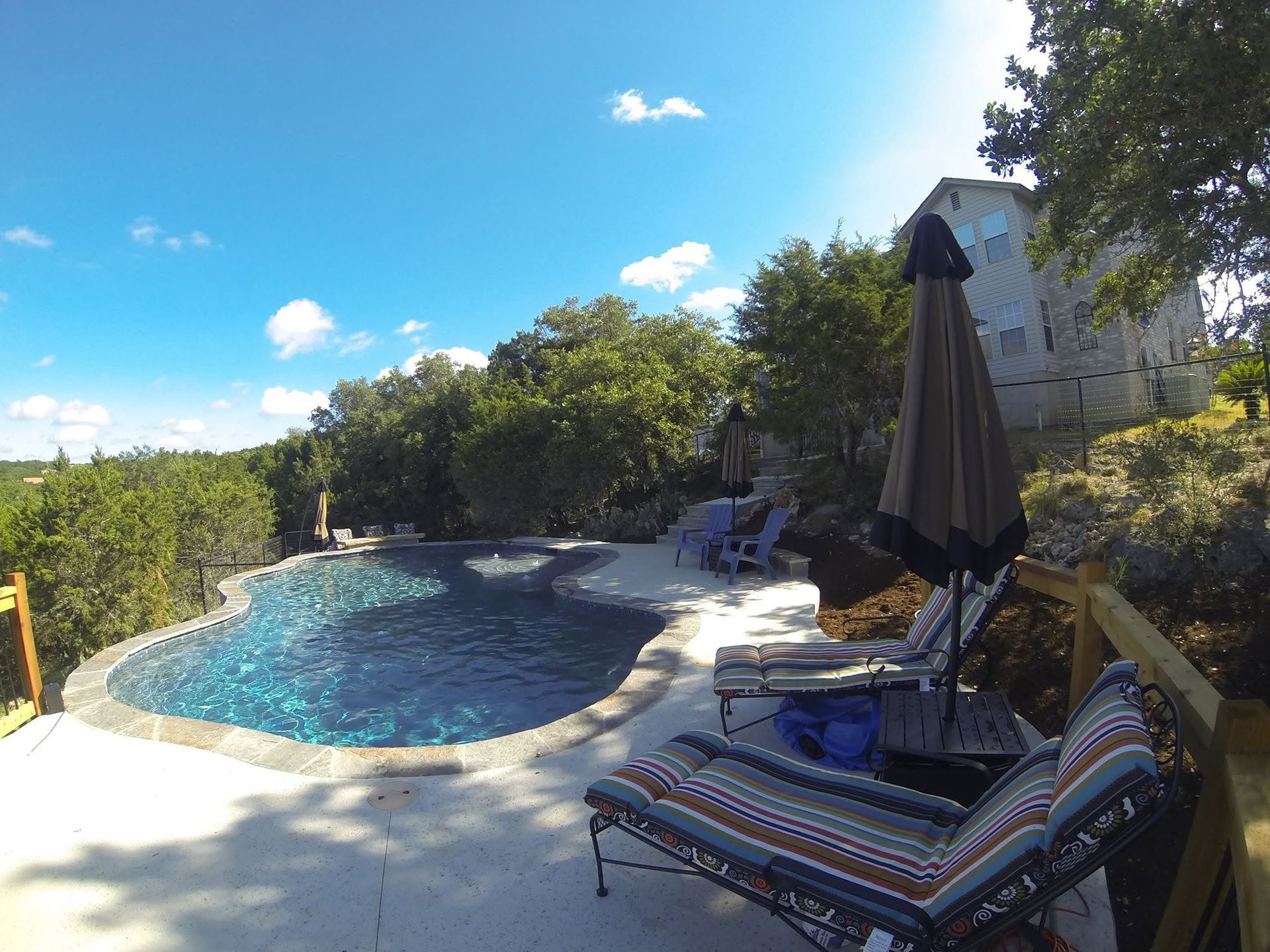 A large swimming pool surrounded by chairs and umbrellas