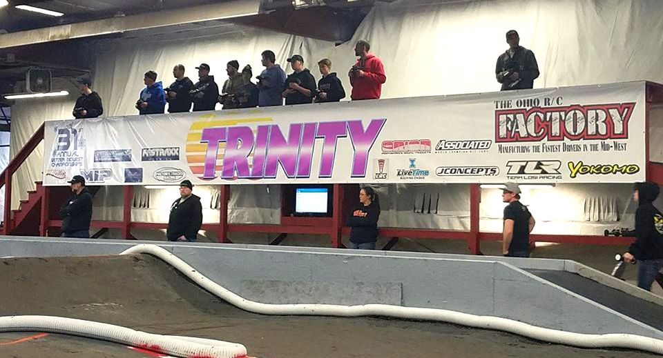 People watching a remote-control car race. A banner reads