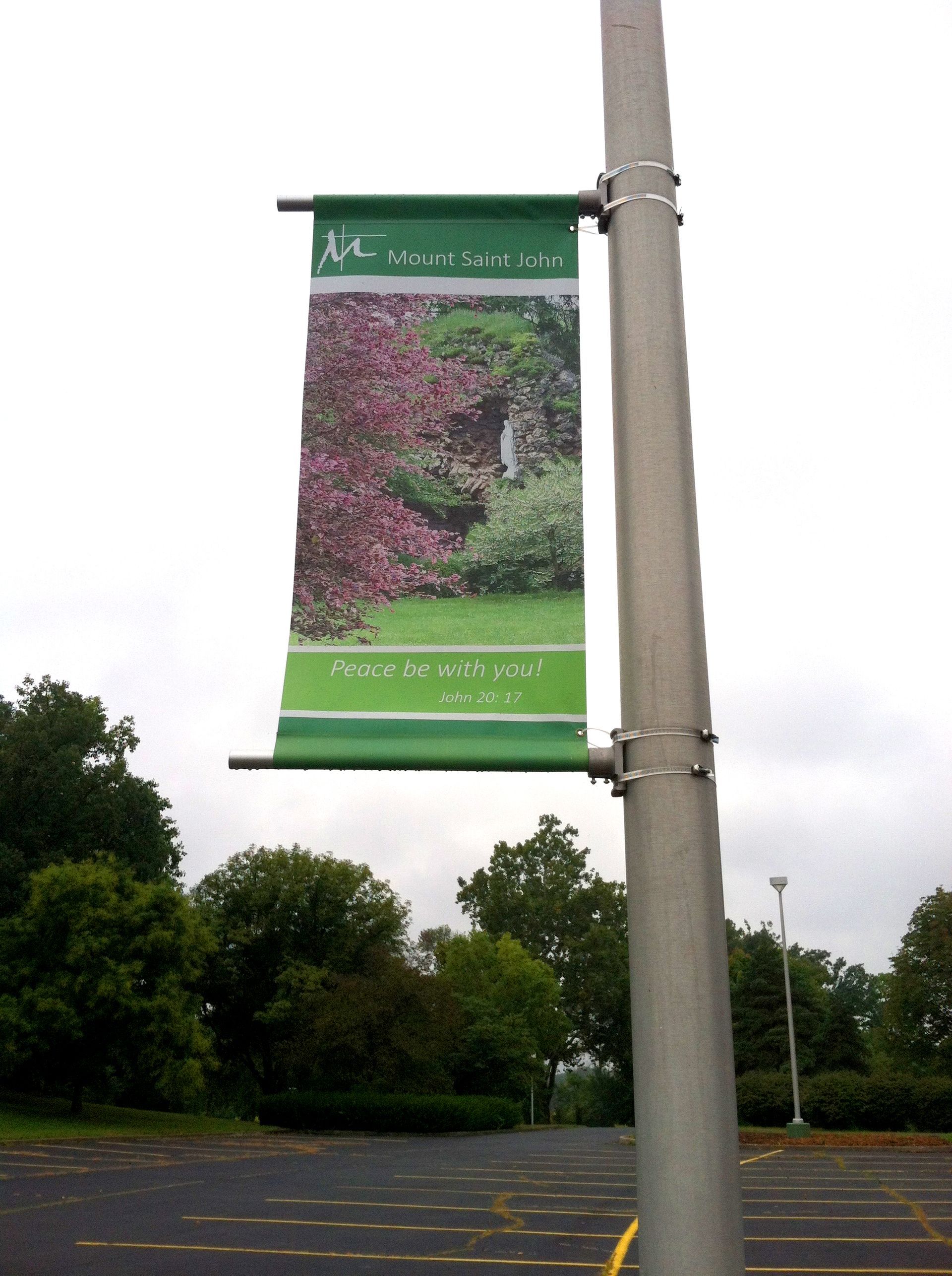 Banner on a pole: green with a garden scene. The banner reads