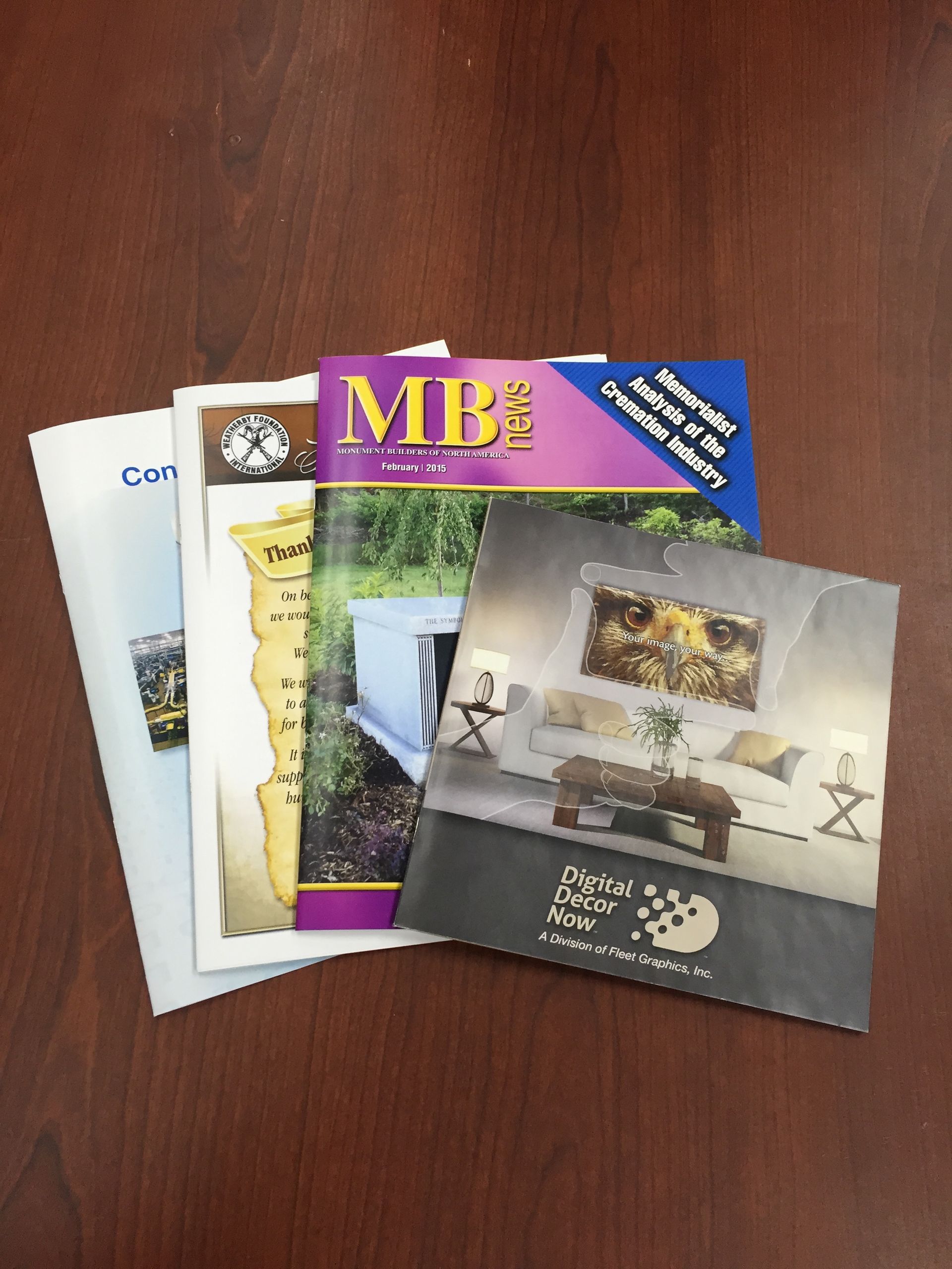 Stack of colorful brochures on a wooden surface.