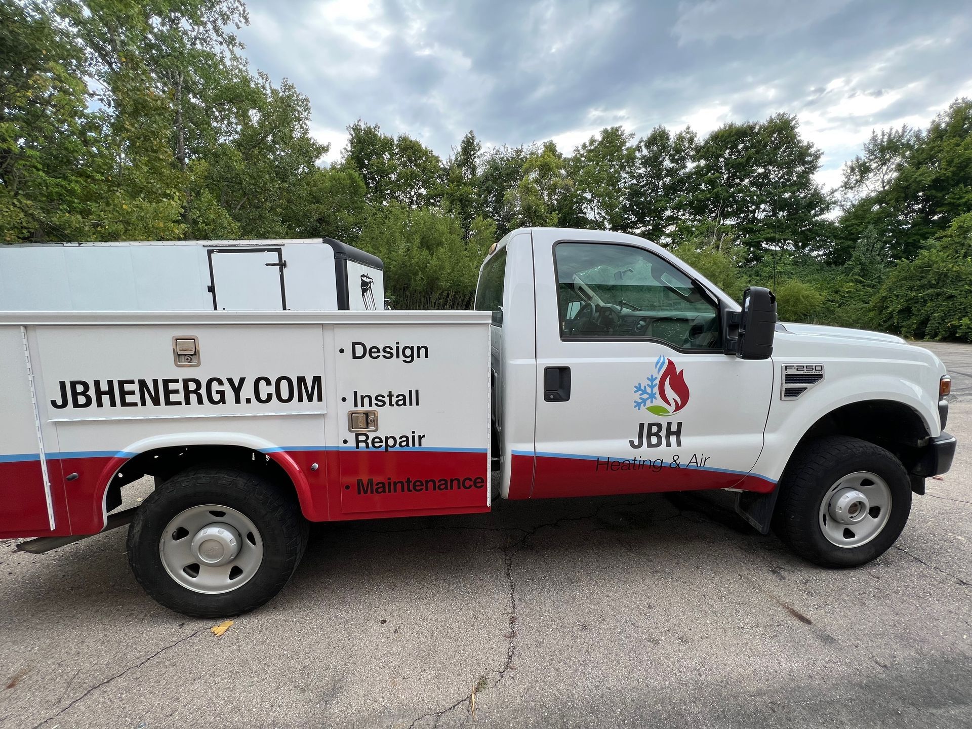 White and red JB Energy service truck parked on pavement.