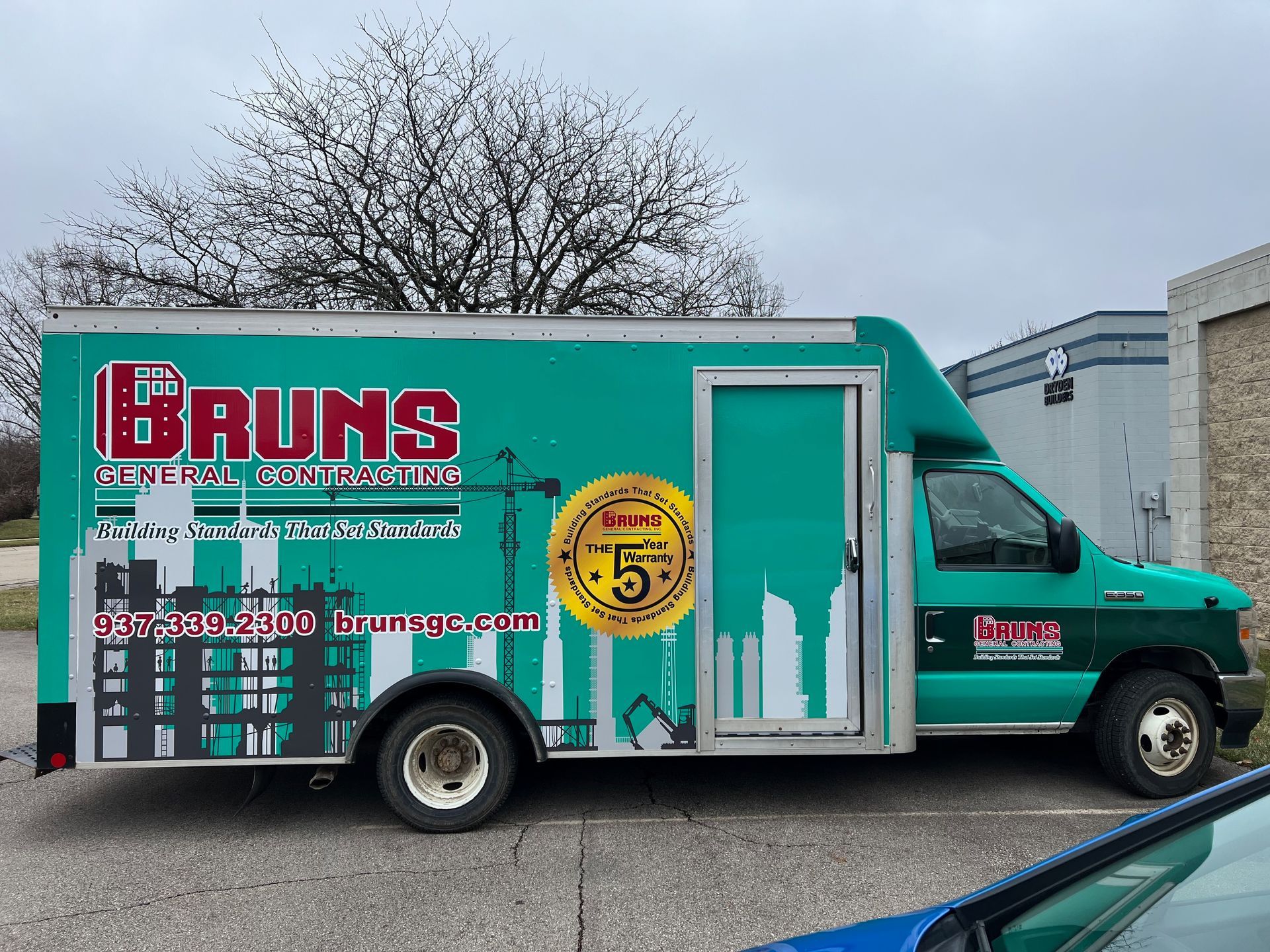 Green Brun's truck with company logo parked outdoors.