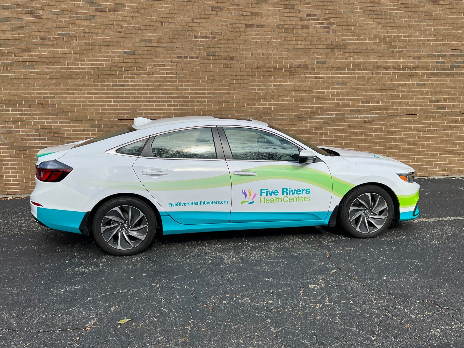 White car with teal and green accents; advertising
